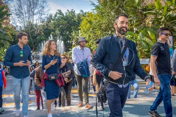 Engaging group tour in Marbella Old Town with a local guide leading visitors through a lush, scenic area.
