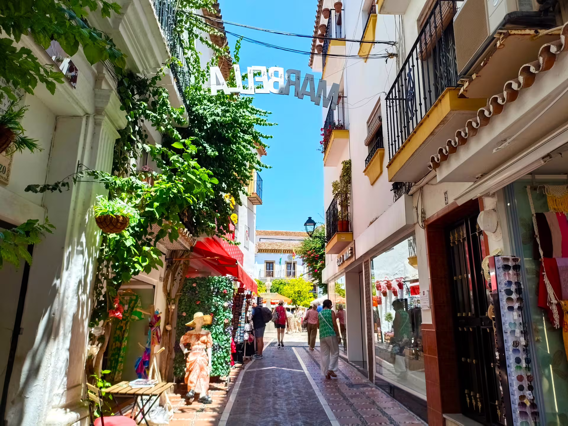 Charming Marbella Old Town lane with shops and balconies, ideal stop on a guided group walking tour