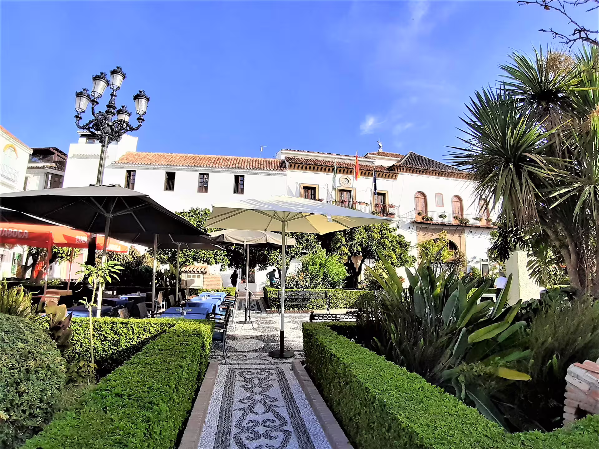 Marbella old town plaza with gardens and café umbrellas, visit on Mijas Marbella Puerto Banus day trip