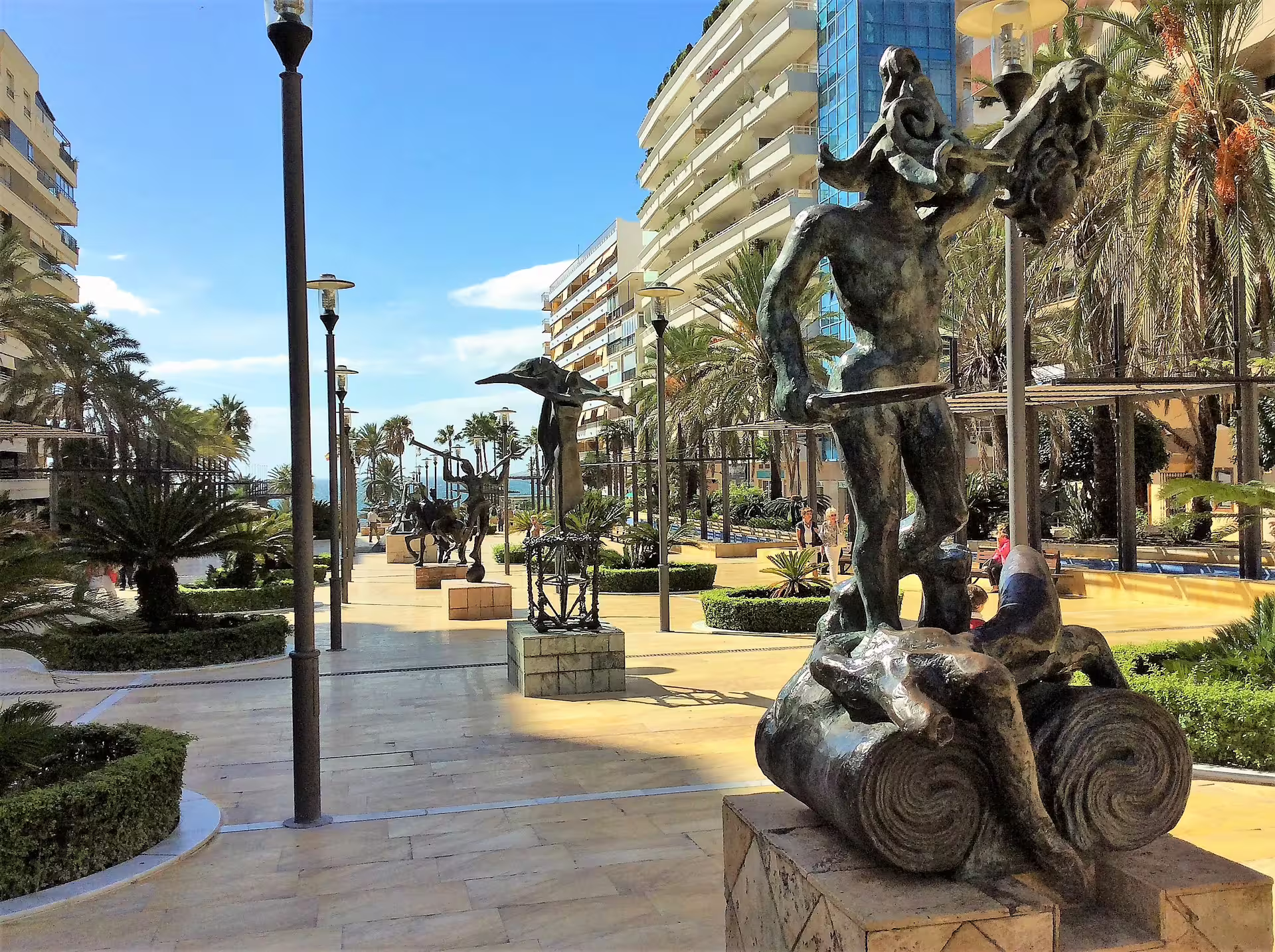 Marbella seaside promenade with modern sculptures and palm trees, part of a private Ronda and Marbella tour
