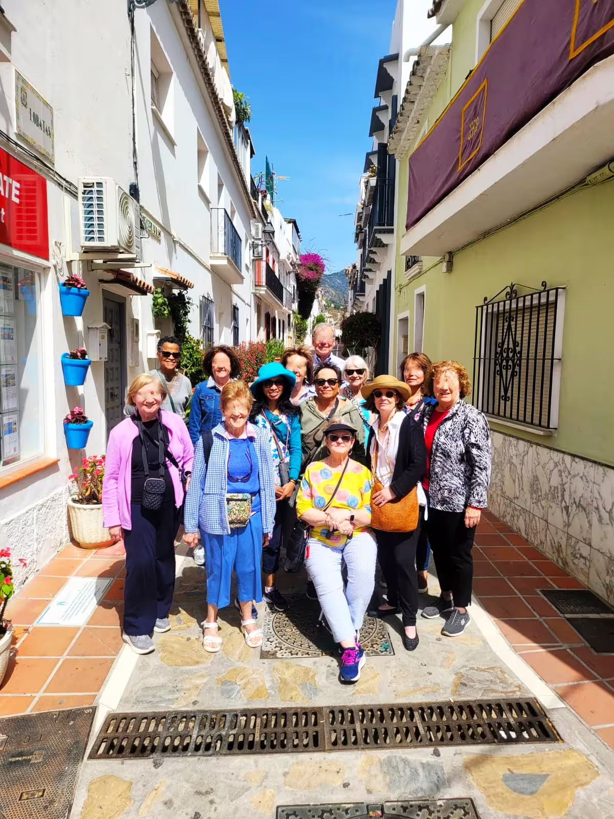 Small group Marbella walking tour photo stop on a sunny Old Town lane with white houses and blooms