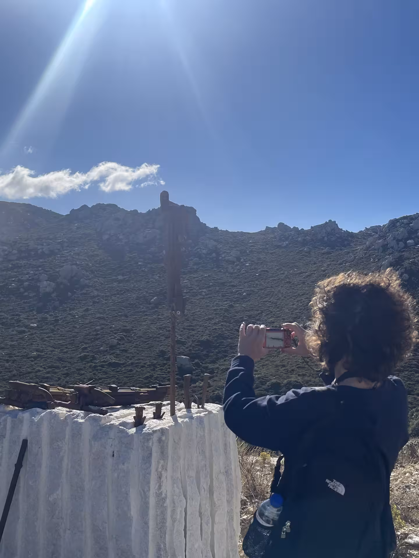 Traveler photographing a giant white marble block and vintage quarry tools on the Marble World experience