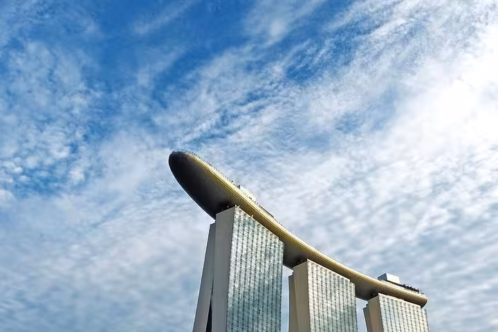 Stunning low-angle view of Marina Bay Sands iconic rooftop under dramatic cloudy sky Singapore private tour