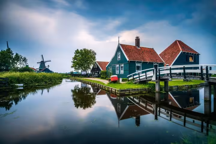 Marken canal with wooden houses, bridge and windmill on Northern Highlights Tour from Amsterdam