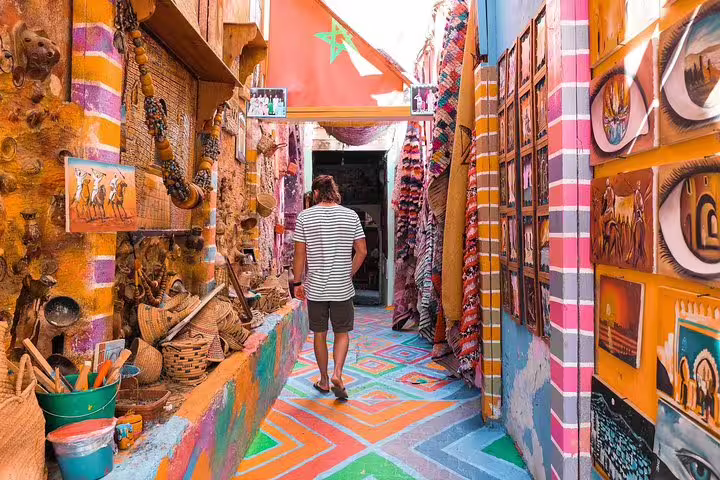 Traveler exploring a colorful Moroccan souk alley, a Marrakech desert tour cultural stop on an 8-day itinerary