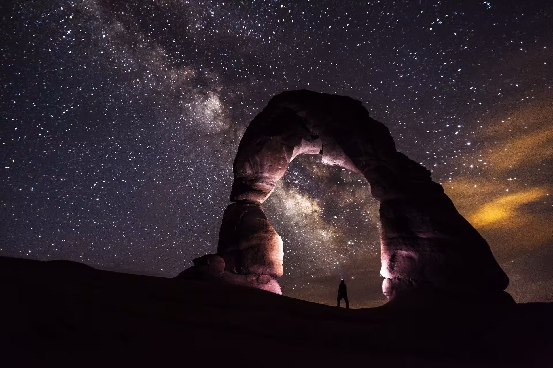 Stargazing under the Milky Way at a desert arch on a 4-day Marrakech to Fez tour via Merzouga Erg-Chebbi.
