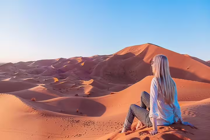 Traveler watching sunset over Merzouga Erg Chebbi dunes on 4 days 3 nights desert tour from Marrakech