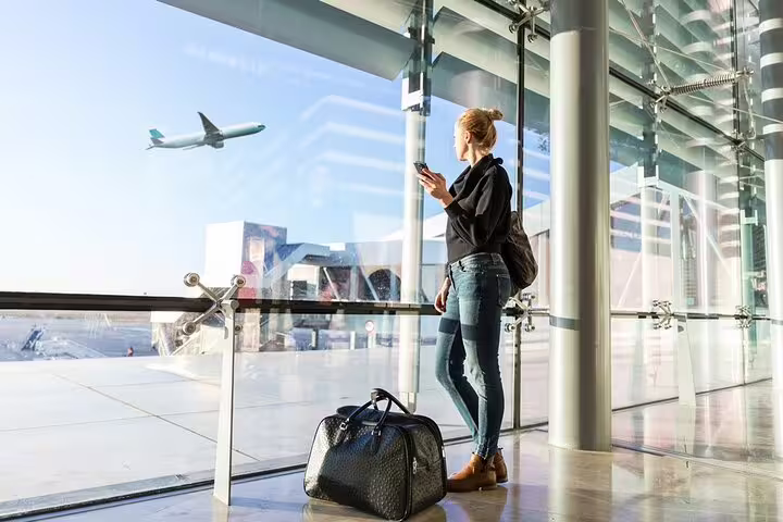 Traveler at airport window with luggage, ideal for Marsa Alam Airport private transfer pickup and drop-off