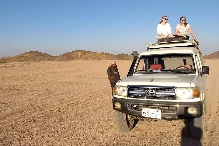 Guests riding on a 4x4 roof during Marsa Alam desert jeep safari, enjoying panoramic dunes and mountains