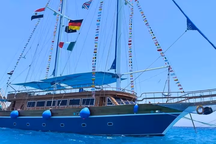Close-up of Marsa Alam pirate sailboat with flags on Red Sea, heading to Turtle Bay snorkeling stop