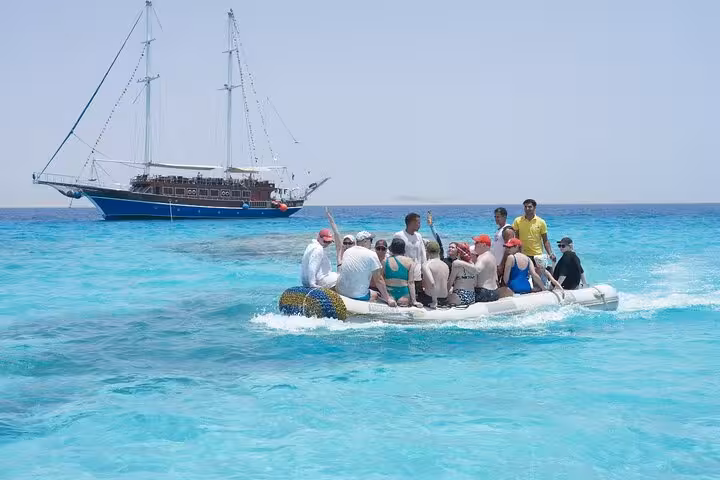 Guests ride a dinghy to a pirates sailing boat cruise in Marsa Alam, heading to Turtle Bay snorkeling