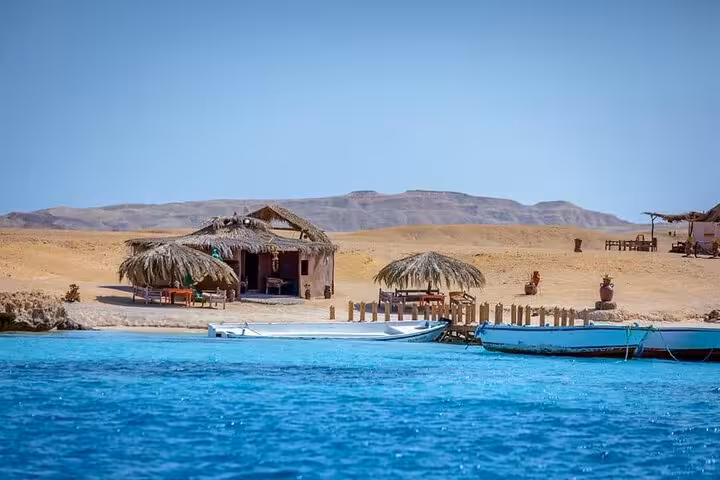 Marsa Alam Red Sea lagoon with boats and beach huts, starting point for private turtle and dugong swim tour