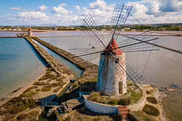 Historic windmills at Marsala Salt Pans with scenic views, featured in a private day trip from Palermo to Segesta and Erice.