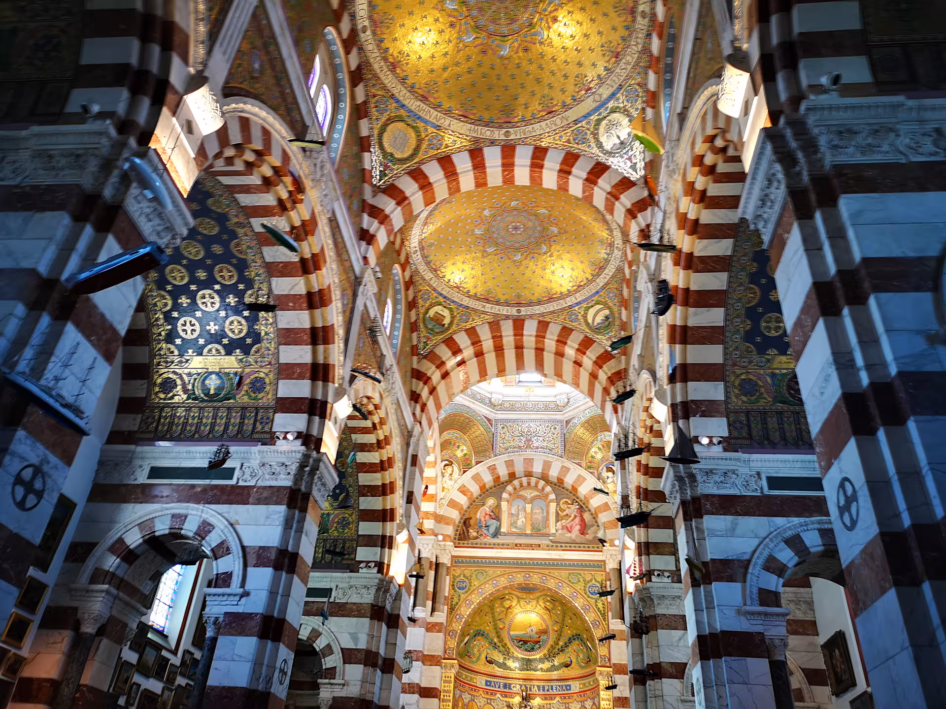Ornate interior of Marseille Cathedral with striped arches and golden mosaics, visited on a private day tour