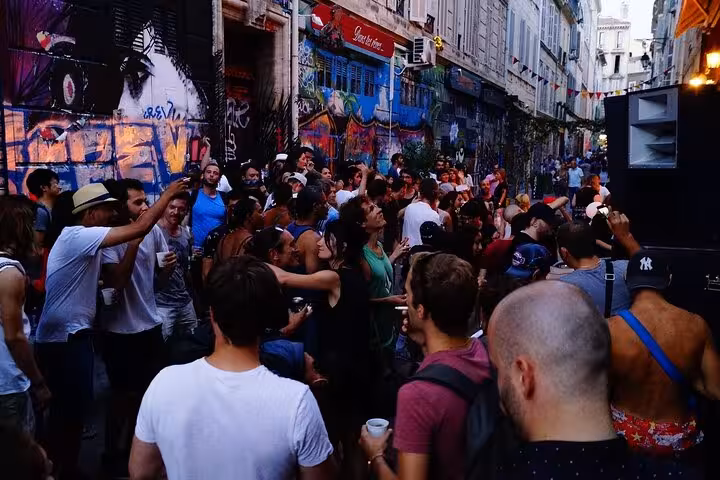 Lively crowd in Marseille’s Cours Julien street art district during guided walking tour and nightlife stop