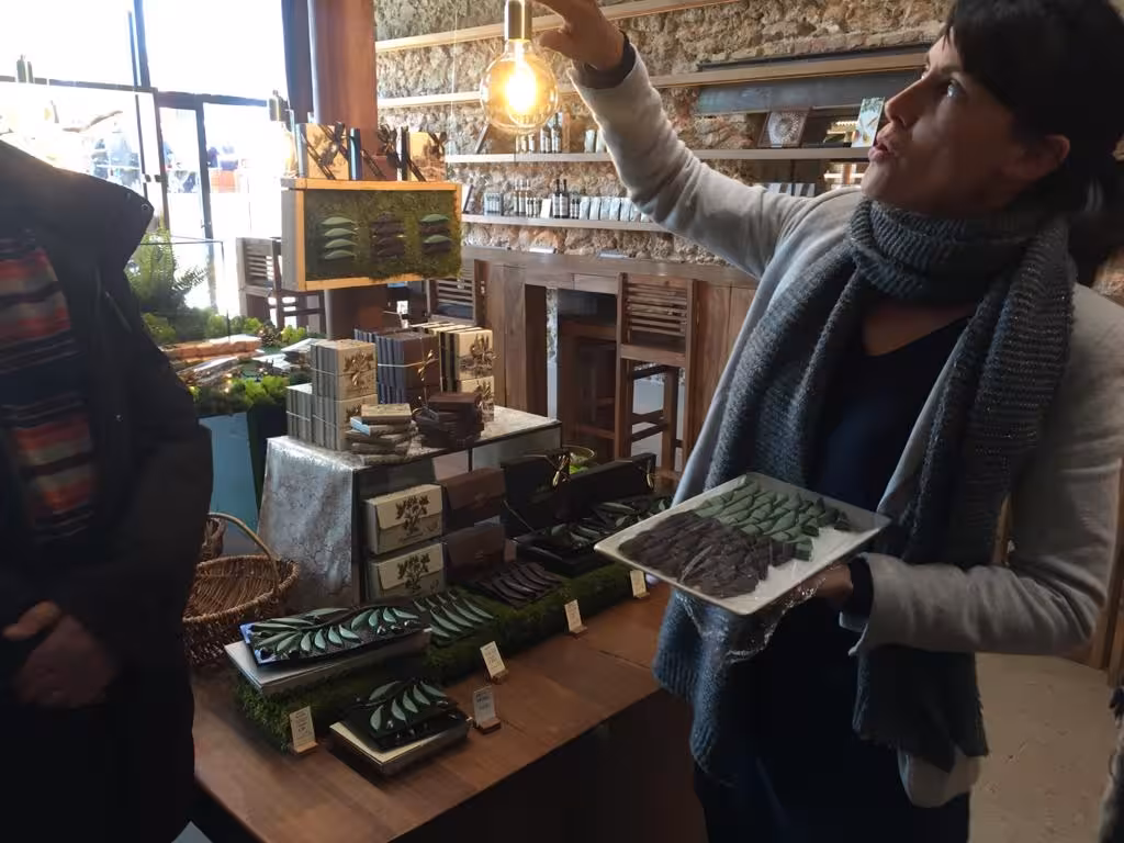Guide presenting artisan chocolates in a Marseille gourmet shop during a guided food tour tasting stop