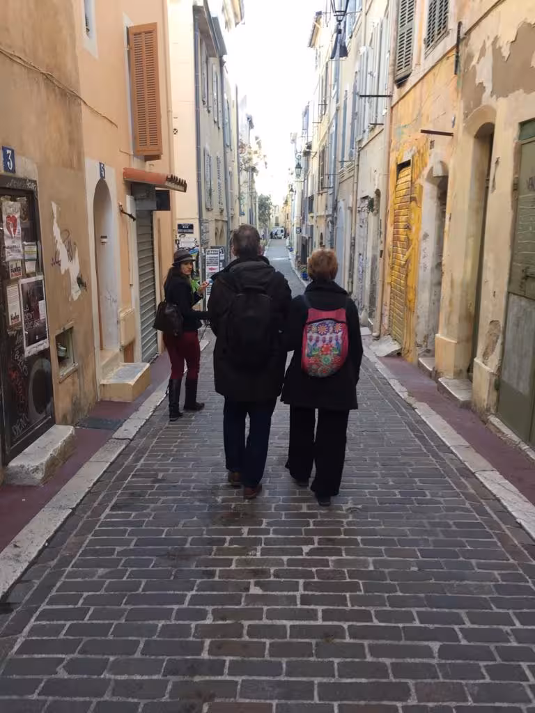 Small group walking a cobblestone alley in Le Panier, Marseille on a guided food tour and tasting experience