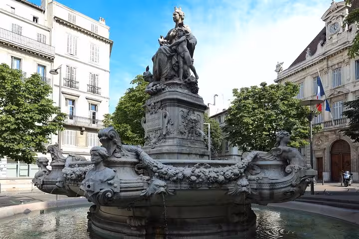Elegant fountain adorned with sculptures in a picturesque square in Marseille, perfect for a private city walk tour.