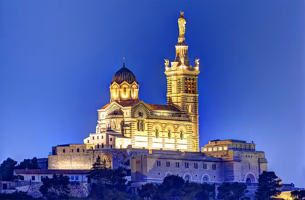 Illuminated Notre-Dame de la Garde basilica at dusk, highlight of a Marseille half-day city tour