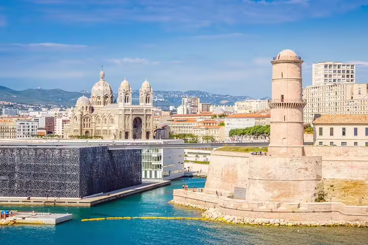 Marseille Old Port with Fort Saint-Jean tower, MuCEM museum, and Cathédrale de la Major under blue sky