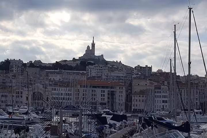 Old Port of Marseille marina with Notre-Dame de la Garde basilica on a private Cassis and city tour