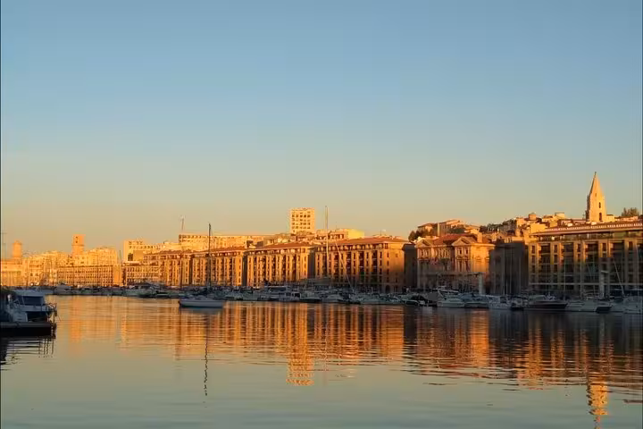 Sunset view of Marseille Old Port waterfront, Provence, with boats and golden reflections on calm water