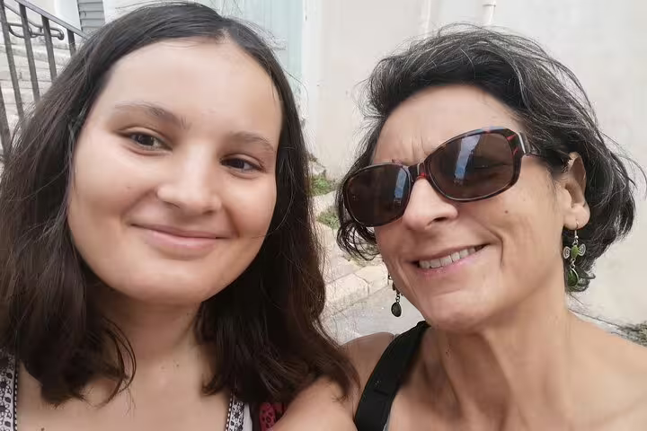 Two women smiling together on a sunny street in Marseille Old Town