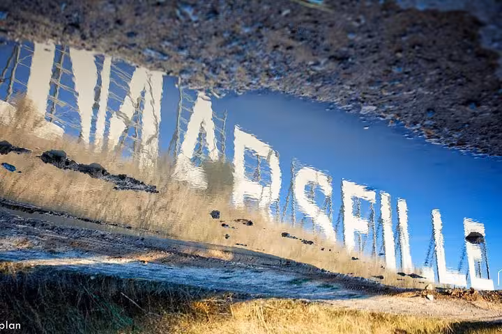 Reflection of “MARSEILLE” sign in a puddle by the port, iconic photo stop on a 3-day local tour