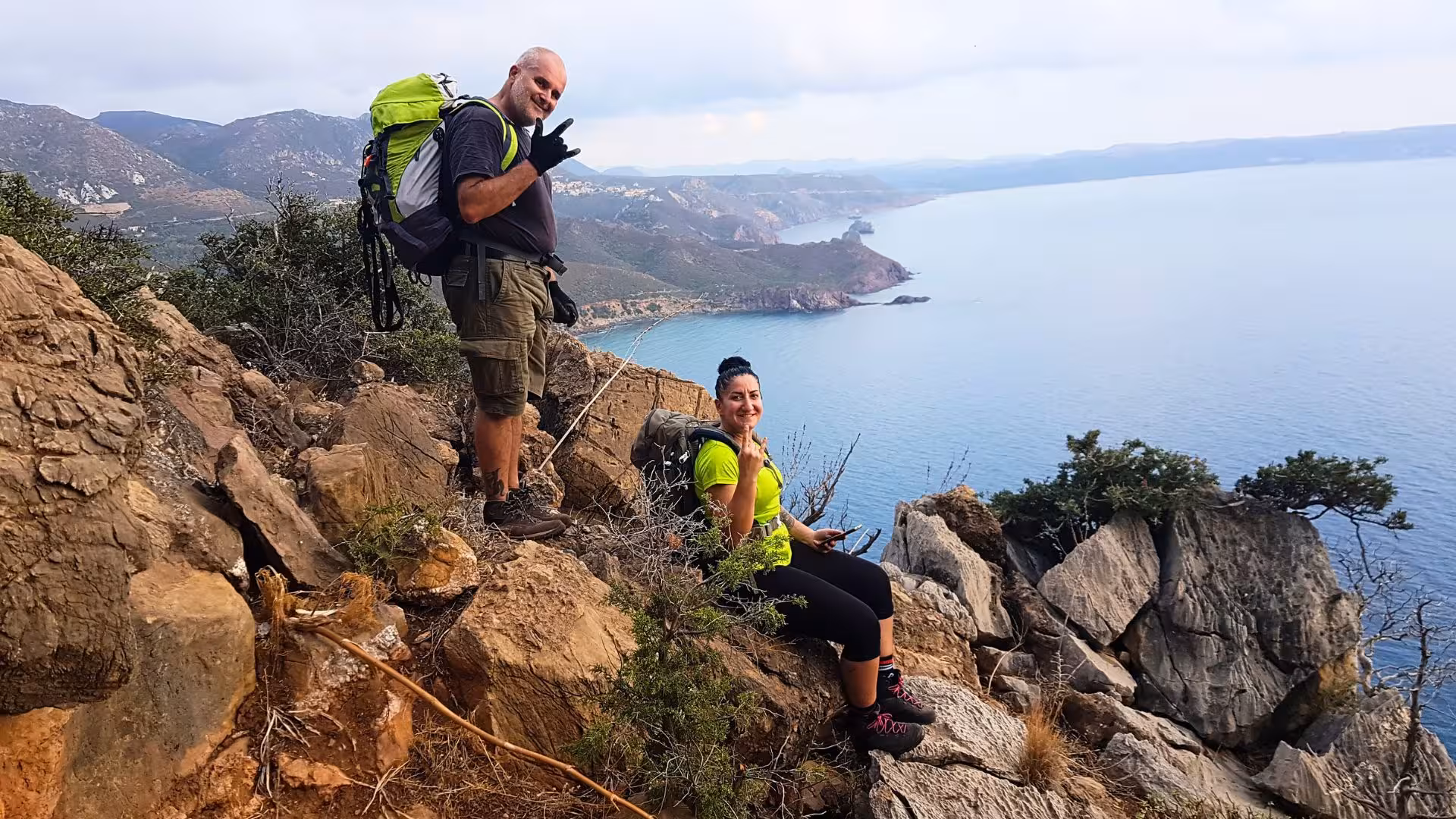 Hikers enjoy breathtaking panoramic views of Porto Flavia coastline during exhilarating dry canyoning adventure.