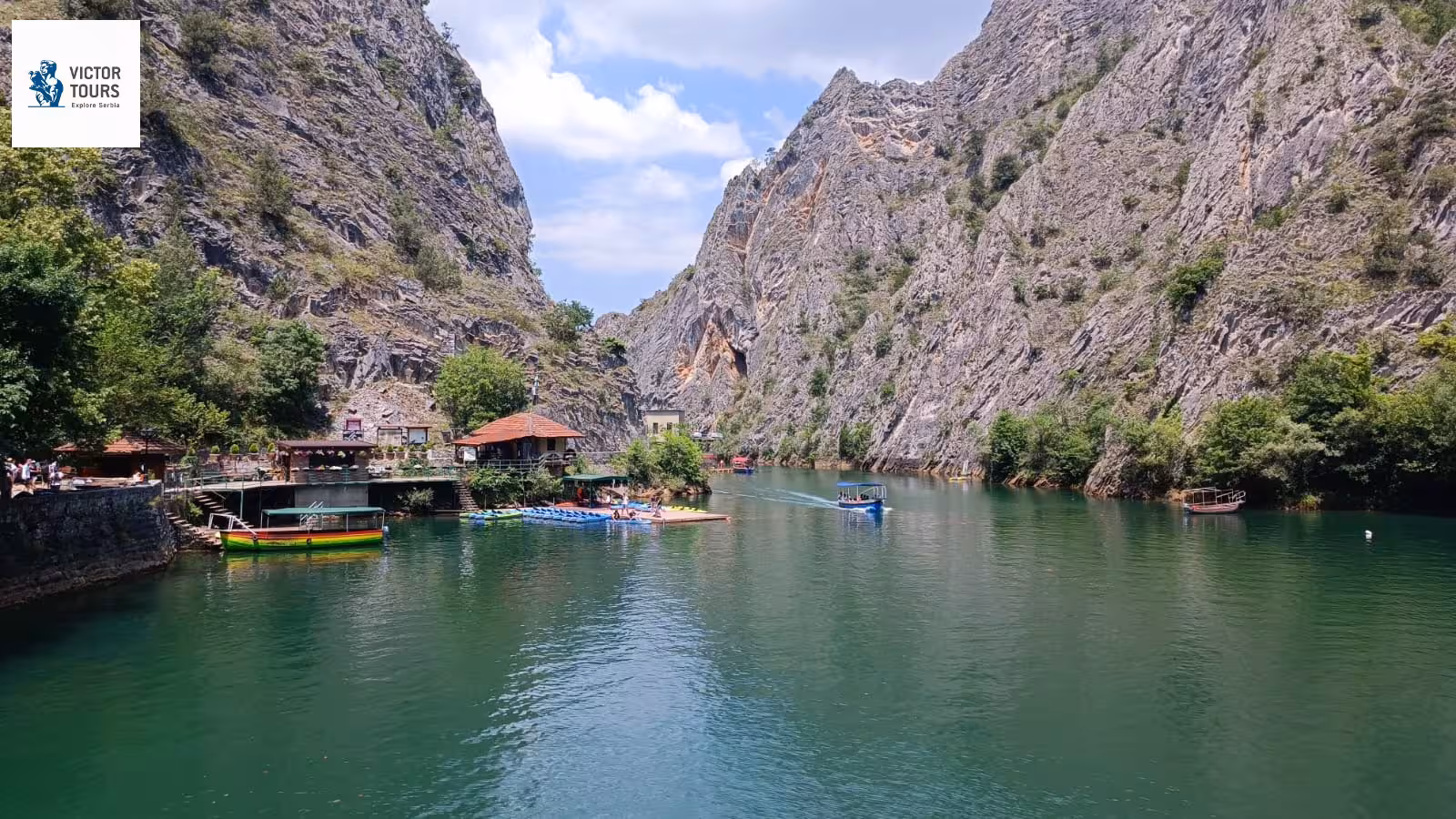 Picturesque Matka Canyon with boats and cafes nestled between rocky cliffs in Macedonia.