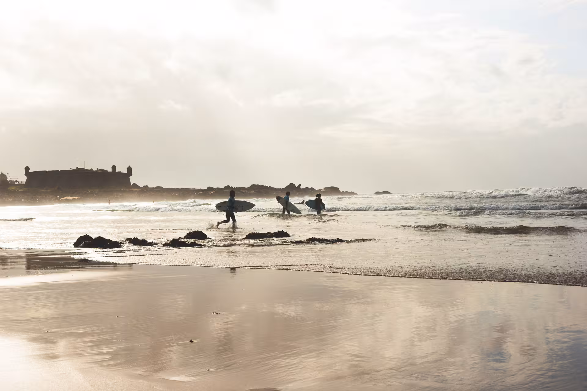 Surfers catching waves at Matosinhos Beach.