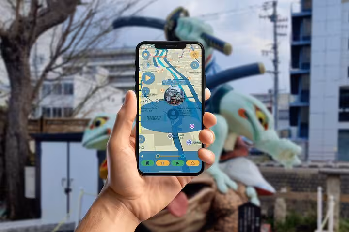 Hand holding smartphone displaying Matsumoto walking tour app map near a dragon sculpture landmark on a self-guided city tour