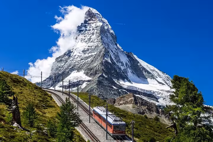 Iconic Matterhorn backdrop with train ascending, ideal for Swiss Travel Pass Tours customizable itinerary.