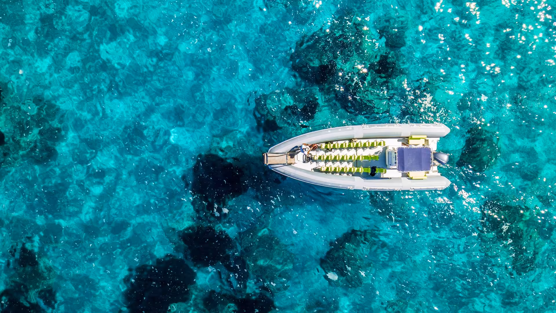 Aerial view of a maxi dinghy on crystal-clear waters in the La Maddalena Archipelago tour from Santa Teresa Gallura.