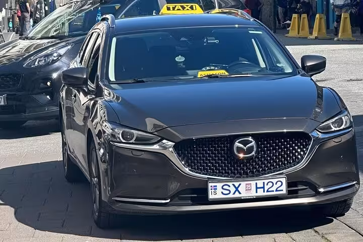 Dark gray Mazda 6 taxi with yellow roof sign and Icelandic license plate SX H22 in Reykjavik