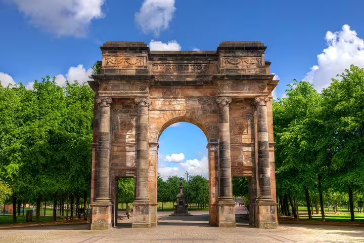 McLennan Arch in Glasgow Green park, a grand sandstone triumphal arch surrounded by lush green trees