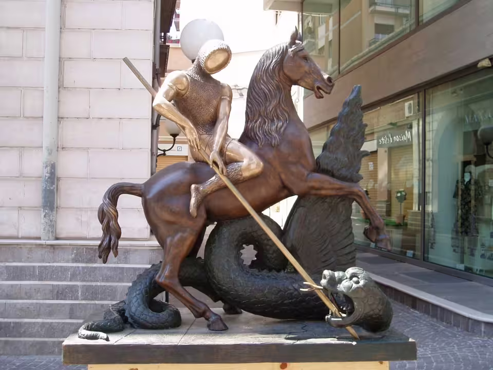 Bronze statue of a medieval knight spearing a dragon in a Calabrian town, a cultural stop on the Legendary Calabria tour route