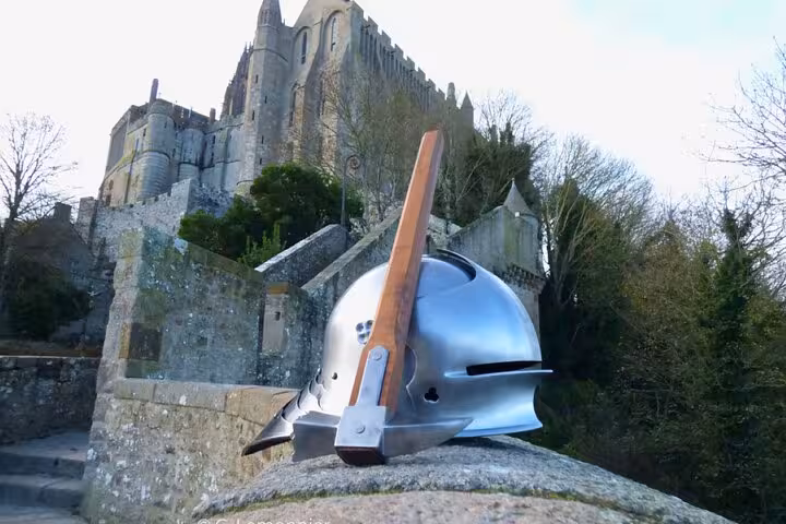 Medieval knight helmet with lance resting on stone wall at Mont Saint-Michel castle, France