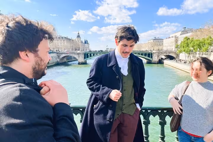 Historical costumed guide speaking to tourists on a bridge over the Seine River in Paris