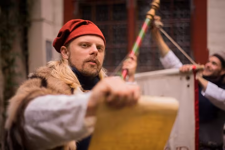 A medieval performer in costume holds a scroll during the Tales of Reval self-guided GPS walking tour in Tallinn