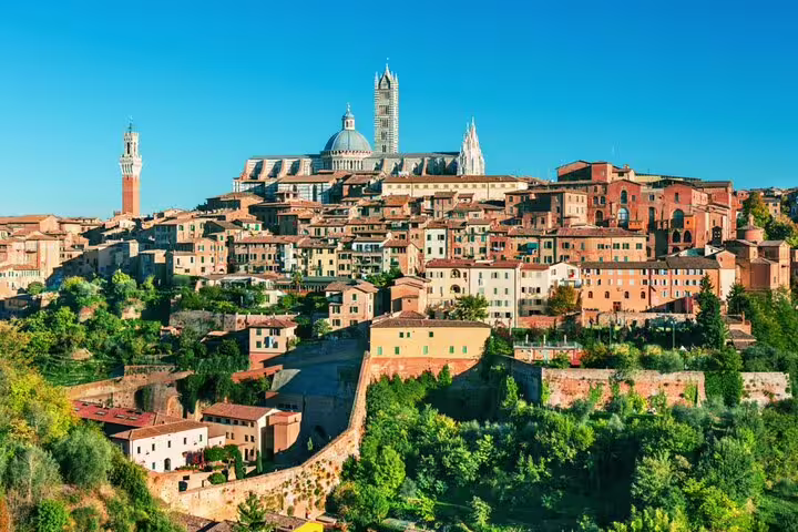Panoramic view of medieval Siena hilltop cityscape with cathedral dome and terracotta buildings, Tuscany Italy