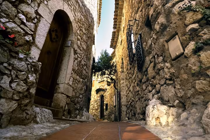 Narrow medieval stone alley with arched doorway in a historic French Riviera village