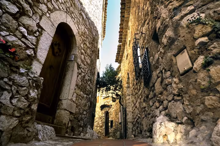 Narrow medieval stone alley with arched doorway in a historic French Riviera village