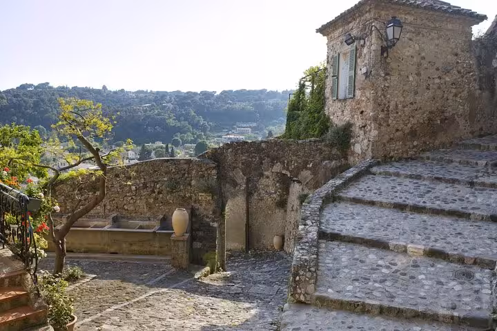 Scenic cobblestone path with ancient stone walls and lush greenery, ideal for a medieval village walking tour.