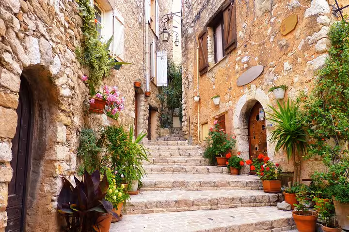 Charming medieval stone alley with flower pots and steps in a Provence village