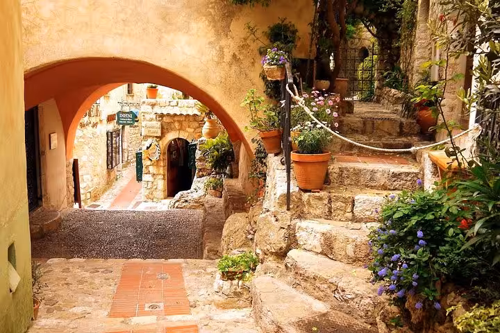 Charming stone archway and flower-lined steps in a medieval village near Monaco, French Riviera