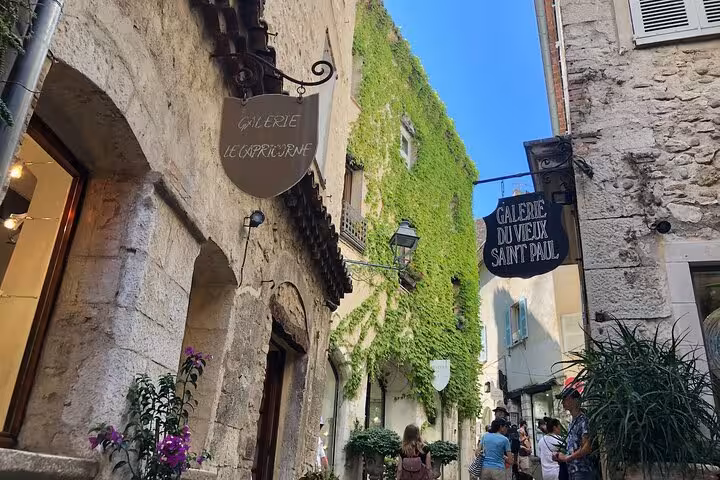 Picturesque street in a medieval village with vibrant galleries and ivy-clad walls, perfect for art lovers on tour.