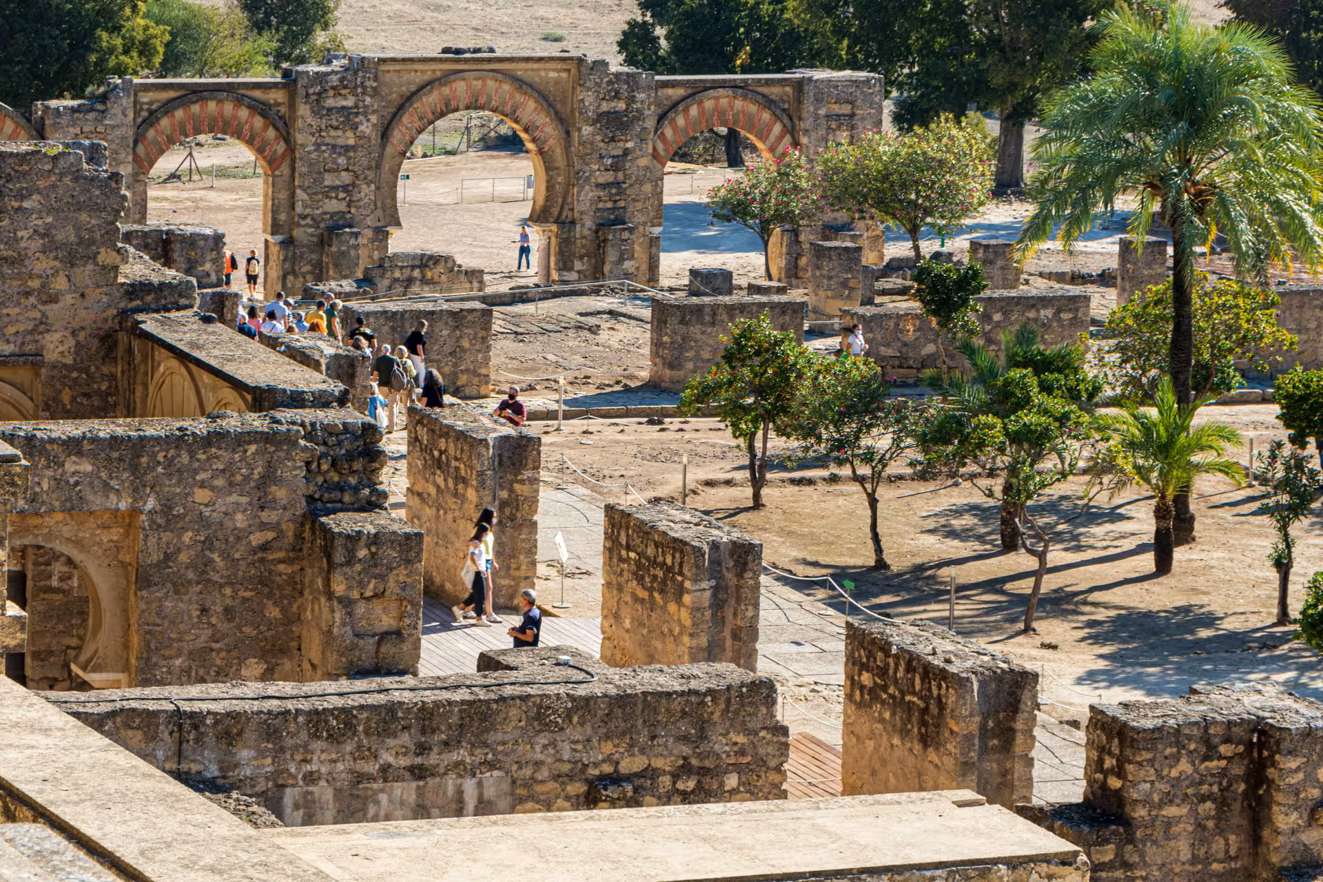 Aerial view of Medina Azahara ruins with arches and gardens, highlighting guided tour experience from Córdoba.