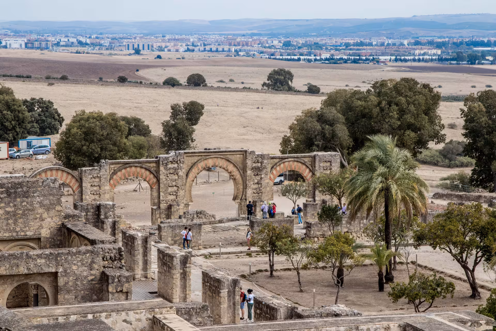Visitors explore the ancient ruins of Medina Azahara with expansive countryside views during a guided night tour.