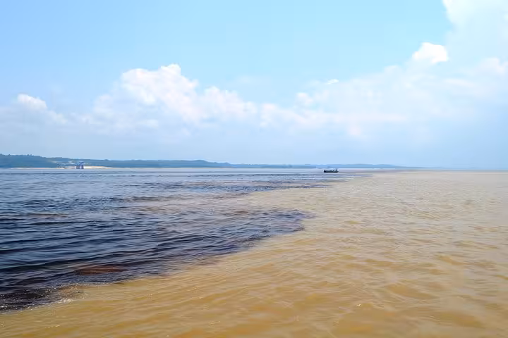 Meeting of the Waters near Manaus showing dark Rio Negro and sandy Solimoes flowing side by side on Amazon tour